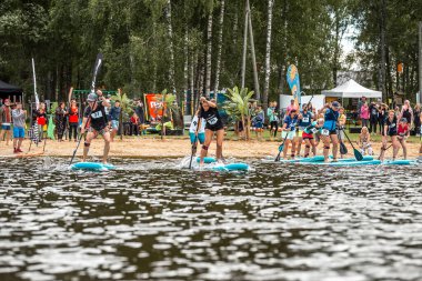 Kalk ayağa SUP yarış rakipleri. SUP festivalinde insanlar ejder raketleriyle kürek çekiyor. muhteşem aktif açık hava eğlencesi.