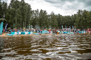 Sıcak yaz gününde ayakta raket kullanan bir sürü insan var. SUP yarışı. muhteşem aktif açık hava eğlencesi.