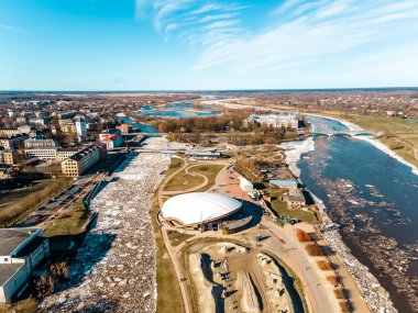 İlkbahar veya kış başında Jelgava şehrinin (posta adası) havadan panoramik görüntüsü ve nehirde büyük buz küpleri