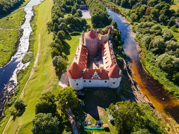 Bauska Ortaçağ Kalesi 'nin üzerinde insansız hava aracı görüntüsü. Önceki bir şatonun kalıntıları ve Letonya 'nın Bauska kentinin kenar mahallelerindeki daha sonraki bir saraydan oluşan kompleks..