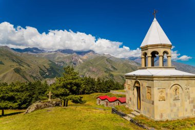 Kazbegi 'de yaz manzarası: Kafkas dağları ve Stepantsminda, Gürcistan' daki St. Ilya Ortodoks Kilisesi (Ioane Natlismcemeli)