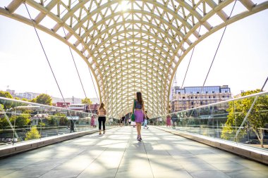 Barış Köprüsü 'nde yürüyen kadın, Georgia' nın başkenti Tiflis 'teki Kura Nehri üzerindeki yaya köprüsü.. 