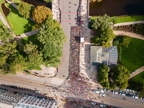 Hundreds of runners getting ready for the marathon. Starting Riga marathon. Aerial top-down view from drone.