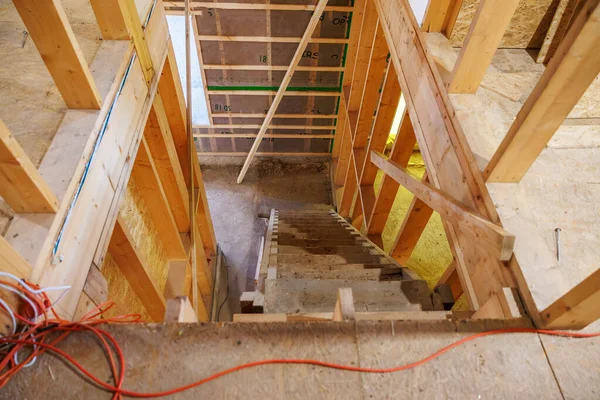 Üst kat manzarası, beton bir bodruma inen dik bir merdiven gösteriyor. Bitmemiş çiviler, açıkta kalan OSB 'ler, kablolar, diş telleri, tozlu izler ve parmaklıklar yok..