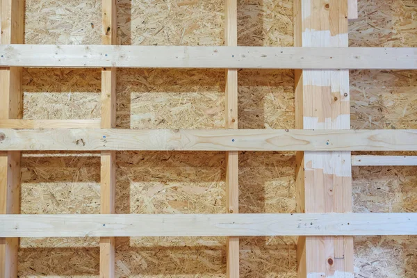 Dikey çiviler ve yatay engeller kapalı alandaki OSB kılıflarına karşı hizalansın. Vidalar, düğümler, ahşap buğday, testere izleri ve yamalı bölümler yapım aşamasında olduğunu gösteriyor.