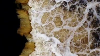 Hava sörfü, keskin bir çizgisel kenar boyunca köpüklü tüylerle karanlık okyanusla buluşur. 