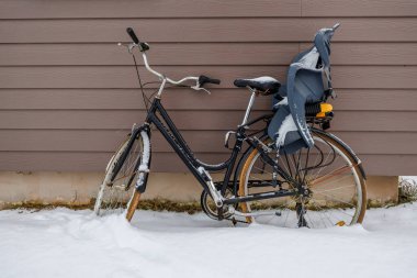 Arka koltukta çocuk koltuğu olan siyah adım bronzlaşma kaplamasına dayanıyor. Kar kürkleri çerçeve, eyer ve çamurluklar. Paslı jantlar ve gömülü lastikler kışın kullanılmadığını gösteriyor.