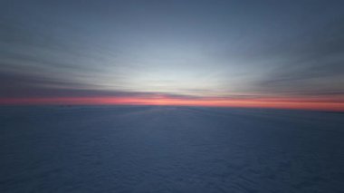 Gökyüzü geniş görüşü, kışın sonlarında ufuk kırmızı turuncu parlarken rüzgar dalgaları, zayıf izler ve deniz buzu üzerindeki basınç sırtlarını gösteriyor..