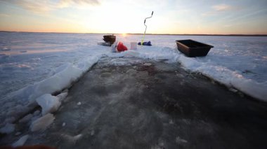 Düşük açı, dikdörtgen bir buz kalıbı, dik bir el kumandası, iki kızak ve balıkçı takımı gösteriyor. Islak bantlar ve kırmızımsı leke günbatımında yakalandığını gösteriyor..