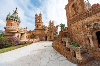 Benalmadena, Endülüs 'teki Castillo Monumento Kolomare süslü taretler, at nalı kemerleri, oymalar ve yumuşak güpegündüz yumuşak sulu tencere ile merkezi kemerli bir kapı gösteriyor..