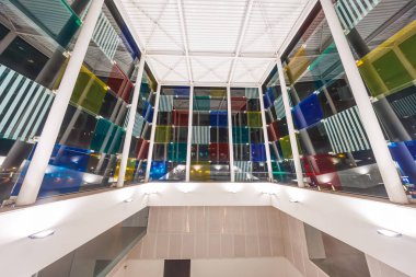 Geceleri Centre Pompidou Malaga 'nın iç kısımları, Malaga, İspanya. Beyaz çelik sütunlar, geometrik çatı, ve çok renkli cam küp camlar çıtır çıtır yapay ışık yansıtıyor.