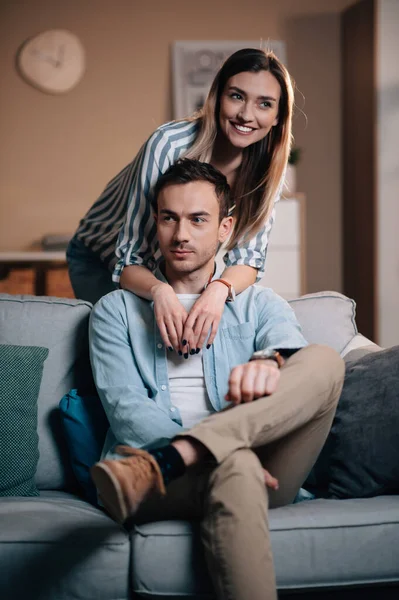 Retrato de una joven pareja con ropa casual en el sofá abrazándose — Foto de Stock