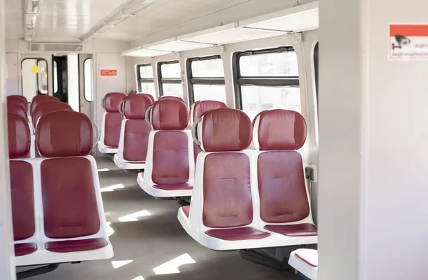 İnsansız tren vagonu. Elektrikli otobüsün boş vagonu. Elekstrichka. Kırmızı koltuklar.