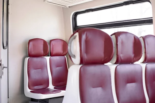 An empty wagon of the electric bus. Elekstrichka. Red seats.