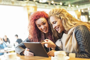 Bir tablet vasıl bakan kafe mutlu arkadaşlar.