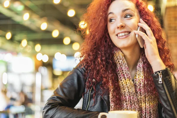 Jeune femme parlant au téléphone dans un café . — Photo