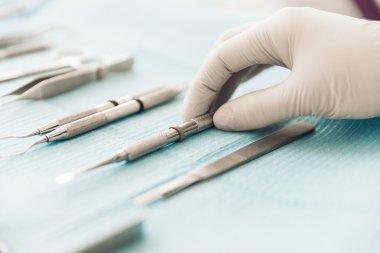 Diş kliniğinde diş araçları tutan el detay. 