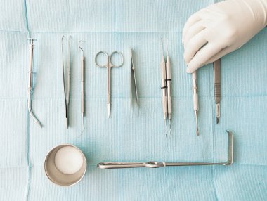 Diş kliniğinde diş araçları tutan el detay. 