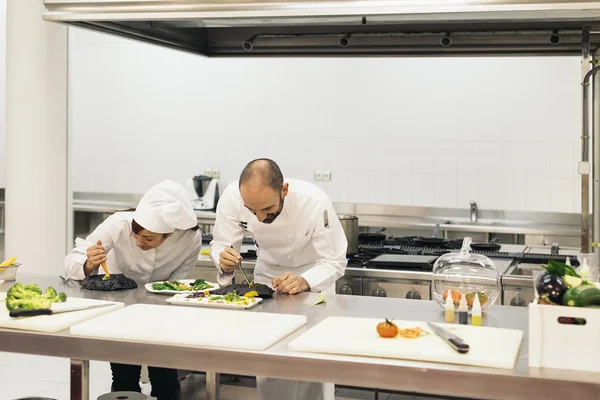 Twee professionals chef-koks koken samen. — Stockfoto