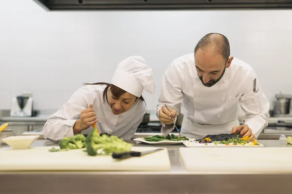 Twee professionals chef-koks koken samen. — Stockfoto