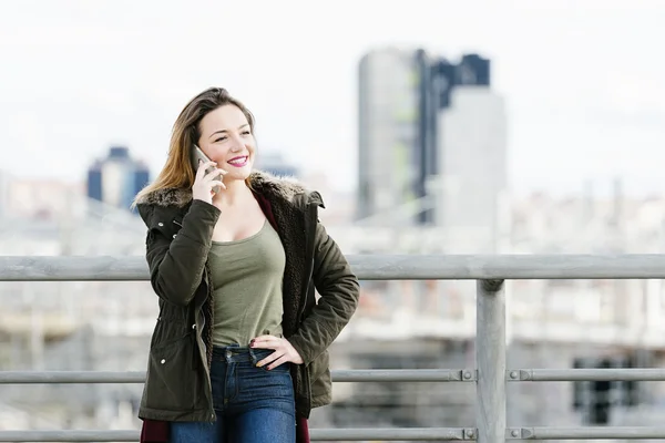 Mooie vrouw aan de telefoon in de stad. — Stockfoto