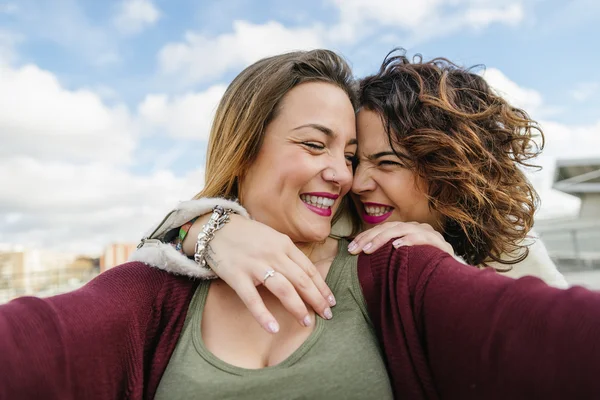 Two beautiful women taking selfiein the street. — Stock Photo, Image