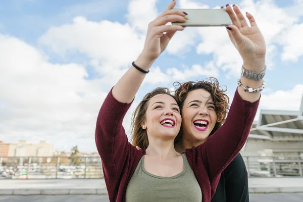 Deux belles femmes prenant selfiein la rue . — Photo