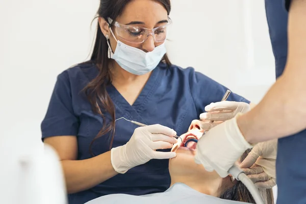 Dentistas con un paciente durante una intervención dental . — Foto de Stock