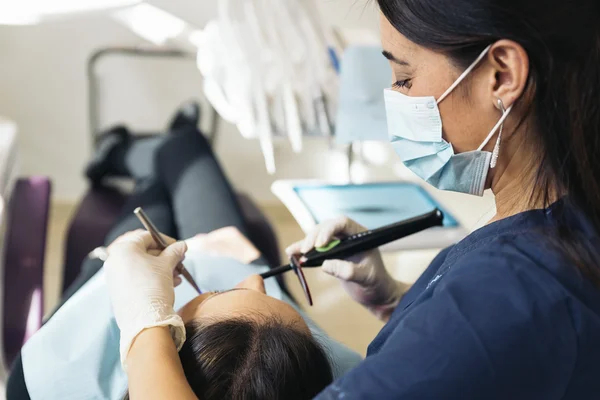 Dentyści z pacjentem podczas interwencji dentystycznych. — Zdjęcie stockowe