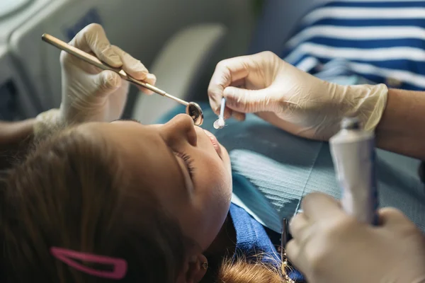 Οδοντίατροι με έναν ασθενή κατά τη διάρκεια μια οδοντιατρική παρέμβαση για κορίτσι. — Φωτογραφία Αρχείου