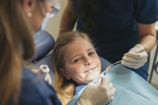 Οδοντίατροι με έναν ασθενή κατά τη διάρκεια μια οδοντιατρική παρέμβαση για κορίτσι. — Φωτογραφία Αρχείου