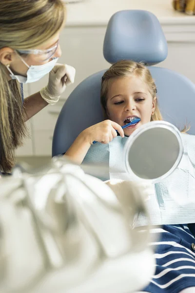Zahnarzt bringt Kind das Zähneputzen bei. — Stockfoto