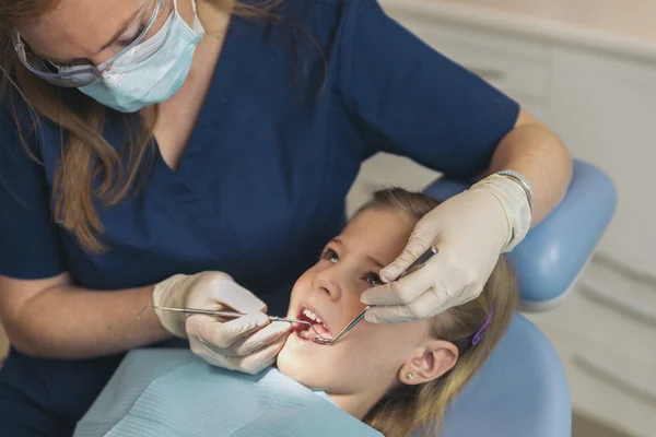 Dentistes avec un patient lors d'une intervention dentaire à la fille . — Photo