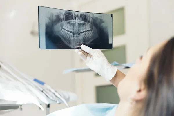 Doctor talking with her patient and teaching a radiograph. Royalty Free Stock Images