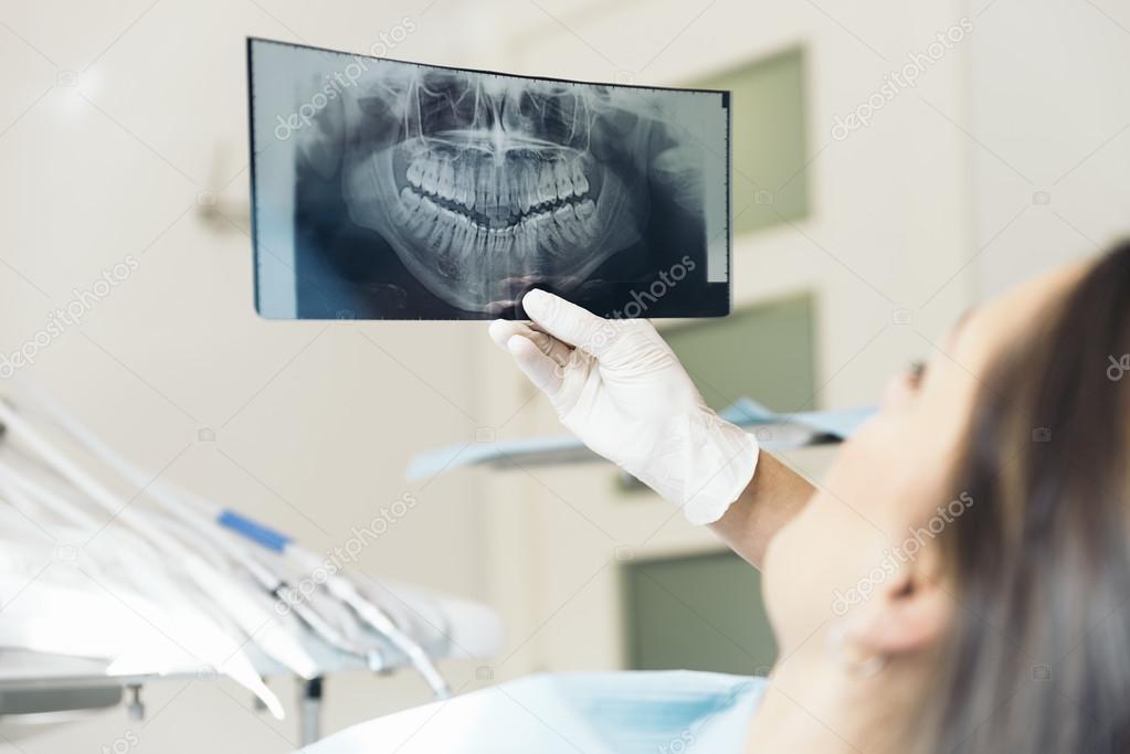 Doctor talking with her patient and teaching a radiograph.
