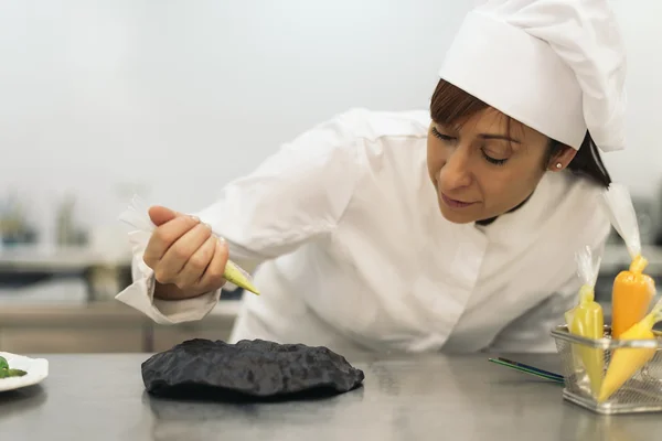 Ganska professionell kock matlagning i ett kök. — Stockfoto