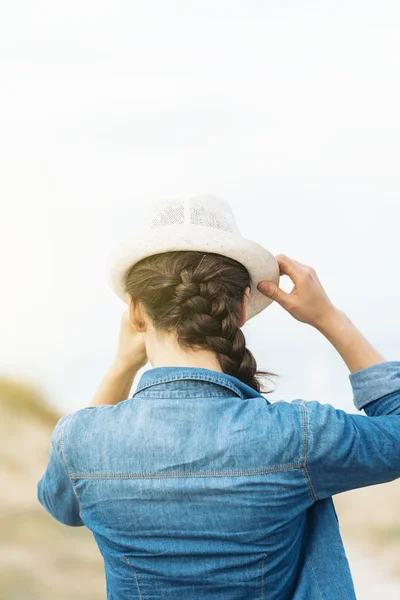 Frau setzt Hut auf. — Stockfoto