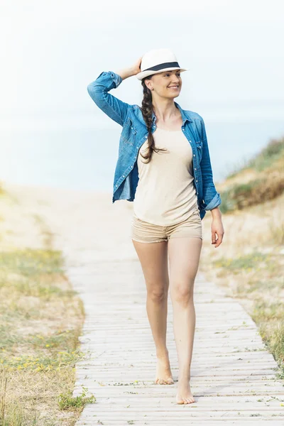 Vrouw lopen weg op het propere strand. — Stockfoto