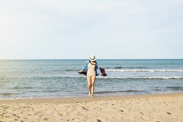 Mujer caminando lejos en la playa idílica . —  Fotos de Stock