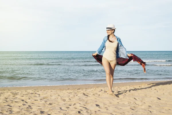 Frau läuft am idyllischen Strand davon. — Stockfoto