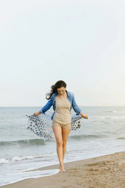 Mujer caminando lejos en la playa idílica . — Foto de Stock