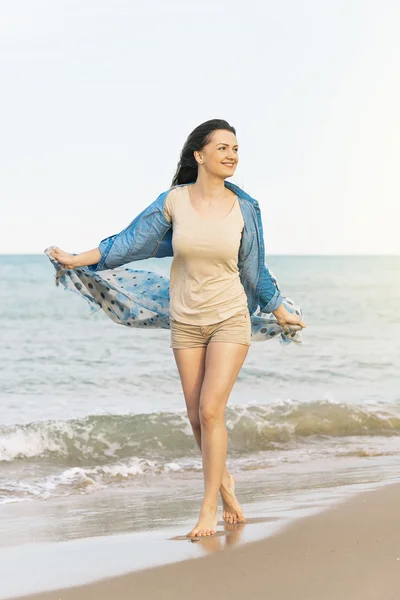 Mujer caminando lejos en la playa idílica . — Foto de Stock