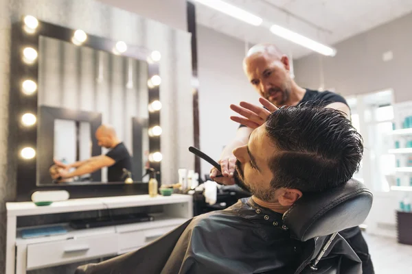 Bärtiger Mann bekommt vom Friseur eine Bartfrisur mit Rasiermesser — Stockfoto