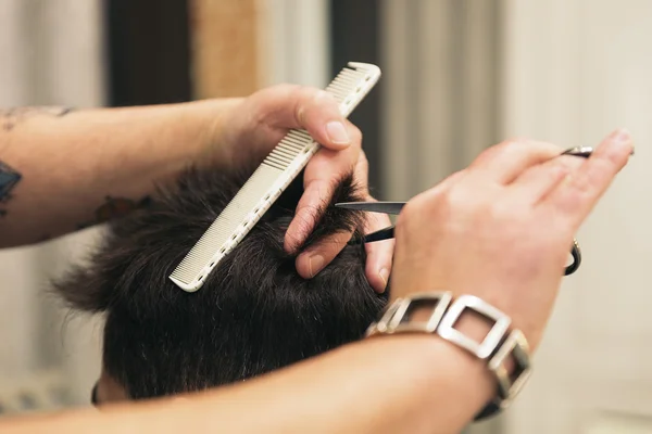 Coiffeur faire la coupe de cheveux des hommes à un homme attrayant . — Photo