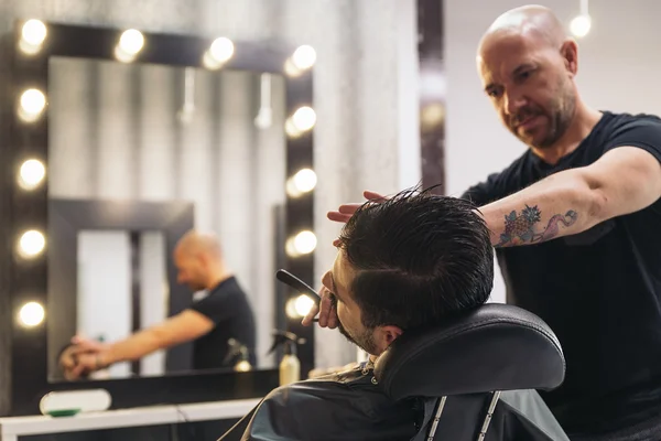 Parrakas mies saada parta hiustenleikkuun kanssa parturi — kuvapankkivalokuva