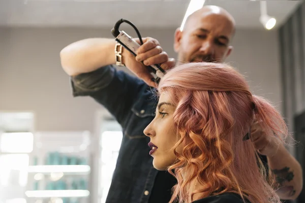 Beautiful woman getting haircut by hairdresser.