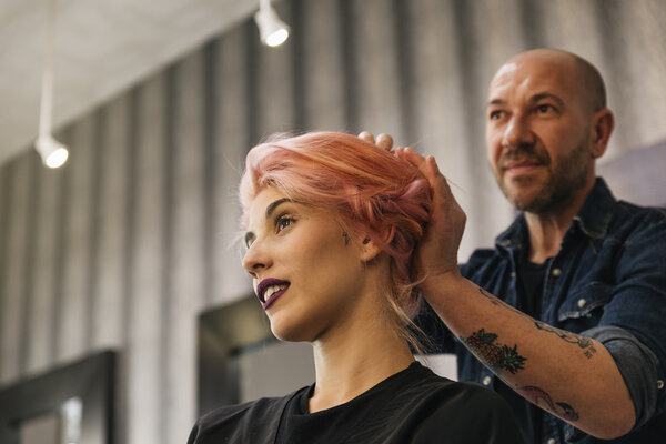 Beautiful woman getting haircut by hairdresser.
