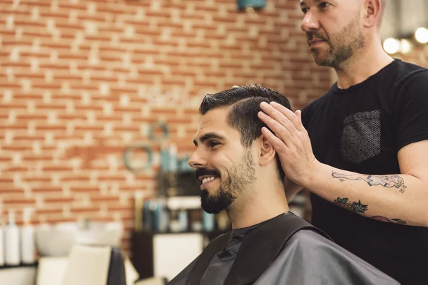 Cabeleireiro fazendo corte de cabelo dos homens para um homem atraente . — Fotografia de Stock