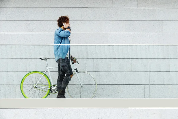 Adam cep telefonu ve sabit vites bisiklet. — Stok fotoğraf