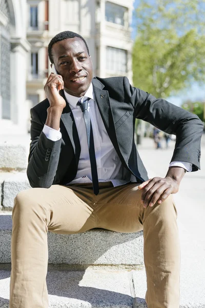 Csinos afrikai ember használ a mobil. — Stock Fotó